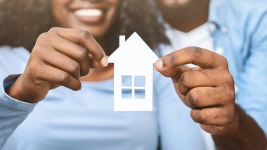 Gayrimenkul, konut ve aile kavramı. Ahşap ev tutan siyah çifte yakın çekim