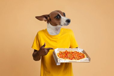 Köpek kafalı biri sarı bir gömlek giyiyor ve önünde bir pizza kutusu tutuyor. Pizzayı sol elleriyle gösteriyorlar..