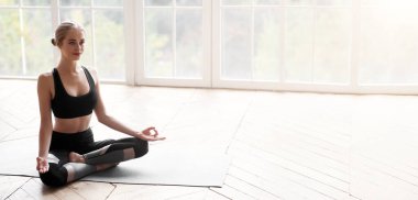 Rahatlamış yogacı kız Lotus poz verip evde meditasyon yapıyor. Stres yok, kopyalama alanı.