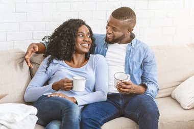 Yeni bir daireyle yeni bir başlangıç. Yeni evdeki kanepede oturan Afro genç çift birlikte bir gelecek planlıyorlar.