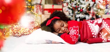 Noel Baba 'yı bekliyorum. Sevimli küçük Afrikalı Amerikalı kız Noel ağacının yanında uyuyakaldı. Hediyeleri düşlüyordu..