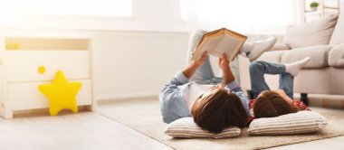 Küçük kız ve babası birlikte vakit geçiriyorlar, evde yerde yatıyorlar, tatlı kızına kitap okuyan bir adam, boş bir alan.
