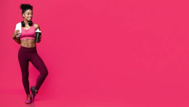 Spor ve egzersiz için besin, spor yiyecekleri konsepti. Havlu ve kulaklık takan sağlıklı, sportif, siyah bir kız. Proteinli, bedava yer var.