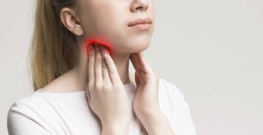 Tiroid bezi sorunu olan bir kadın, boynuna dokunuyor, yakın plan, panorama.