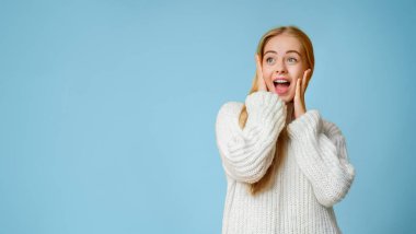 Sersemlemiş, ağzı açık güzel bir kız. Elleri sarı arka planda yanaklarına dokunuyor. Fotokopi alanına bakıyor.