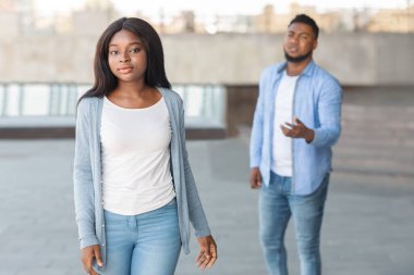 Açık havada tartıştıktan sonra ayrılan bir çift. Üzgün siyah kadın, kalması için yalvaran erkek arkadaşını terk ediyor.