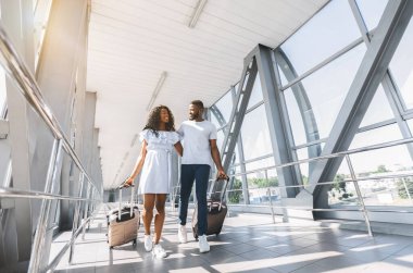 Balayına gidiyor. Havaalanında bavulile Afrikalı-Amerikalı çift gezginler, freee alan