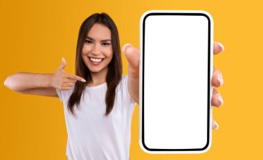 Şu siteyi kontrol et. Elinde beyaz ekranla akıllı telefonu tutan gülümseyen bir kadının portresi, kameraya yakın cihazları gösteriyor ve boş boş alanı olan cihaza işaret ediyor.