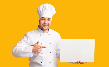 Pozitif Aşçı Parmakla Gösteriyor Boş Beyaz Tahtayı Ellerinde Gösteriyor Sarı Stüdyo Arkaplanının Üzerinde Duruyor. Model