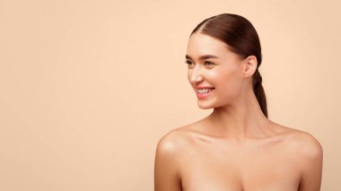 Boş Alan 'a Bakan Mutlu Genç Kadın Gri Arkaplan Üzerine Üstsüz Poz Veriyor. Reklam afişi için Bayan Portresi. Doğal Kadın Güzeli. Panorama, Stüdyo Çekimi