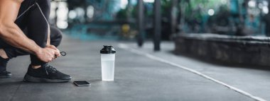 Spor salonunda ayakkabı bağcığı bağlayan, antrenmana hazırlanan, boş alan, kesilmiş