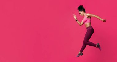 Kırmızı stüdyo arka planında spor yapan Afrikalı genç bir kadın.