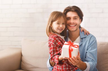 Mutlu baba-kız portresi, hediye kutusu, evdeki kanepe, aile gelenekleri konsepti.