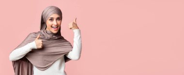 Hoşuma gitti. Türbanlı Mutlu Arap Kız Pembe Arkaplan Üzerinde İki Elle Başparmak Yukarı, Boş Alan