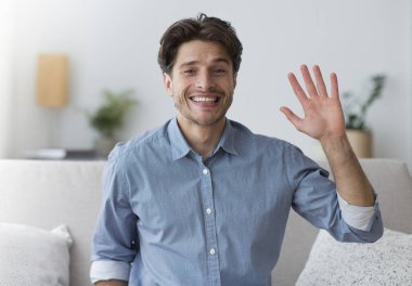 Hoş geldiniz. Gülümseyen adam el sallıyor ve kameraya bakıyor..
