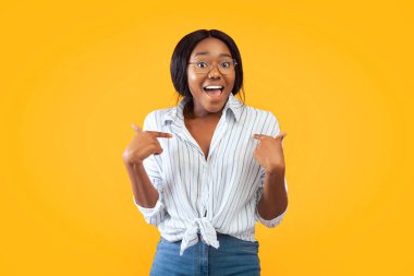 Look At Me. Positive Black Girl Pointing Fingers At Herself Smiling At Camera Standing Over Pink Background. Studio Shot clipart