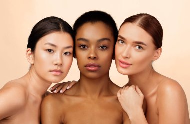 Beauty. Portrait Of Three Mixed Girls Looking At Camera Posing Naked Over White Background. Studio Shot