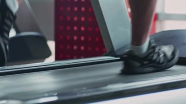 Kilo verme konsepti. Erkek ayağı koşu bandında hızlı yürür, vücudu formda ve formda tutmak için, yaklaşır