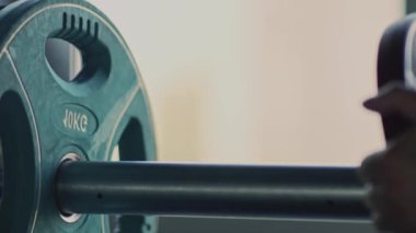 Güçlü adam ağırlık kaldırıyor, antrenmanı için spor aletleri hazırlıyor, kapatın. Ağırlık kaldırma kavramı