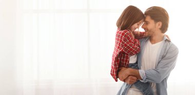 Neşeli, sevgi dolu baba, küçük anaokulu kızını taşıyor, evde birlikte vakit geçiriyor, boşluğu kopyalıyor.