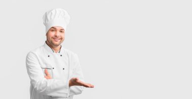 Restoran Şefi, Beyaz Stüdyo Arkaplanında Boş Alan Pozisyonunu Göstererek El Hareketi Yapıyor.