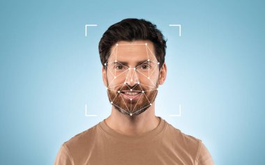 Yüzünde yüz tanıma teknolojisi sergilenirken sakallı bir adam güvenle gülümsüyor..