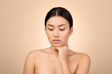 Çift Çene Önleme. Yüzüne Dokunan Asyalı Kadın Açık Gri Arkaplan Üzerindeki Antiage Cilt Tedavisinden Endişeli. Cilt Bakımı Sorunları ve Güzellik Kusurları