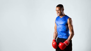 Öfkeli Öfke. Kırmızı boks eldiveni giyen sinirli siyah adam dövüşmeye hazırlanıyor.