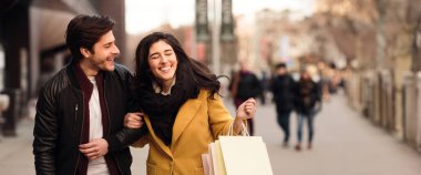 Heyecanlı çift hafta sonları birlikte alışveriş yapıyor, dışarıda konuşuyor ve gülüyor, fotokopi alanı olan bir panorama.
