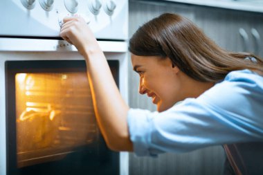 Karantina eğlencesi. Neşeli ev hanımı evde yemek pişiriyor, boş yer var.