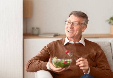 Gülümseyen kıdemli centilmen salatanın tadını çıkartıyor. Yaşlılıkta sağlıklı beslenme. Boş Alan, Seçici Odaklanma