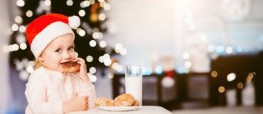 Geleneksel Noel hediyesi. Kurabiyeli süt içen tatlı kız, boş alan.