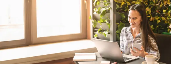 stock image Young beautiful woman searching information in internet via laptop for creating business plan in cafe, free space