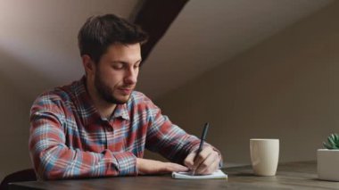İlham krizi. Genç adam deftere fikirler ya da pazarlama planı yazıyor, ama kağıt kağıtları yırtıp atıyor, yavaş çekim