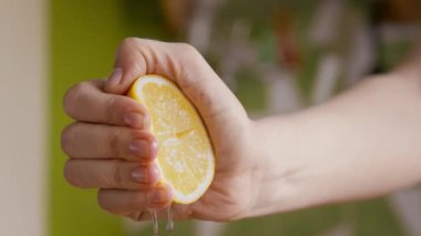 Kadın eli taze limon sıkıyor, meyve suyu yapıyor, kapat.