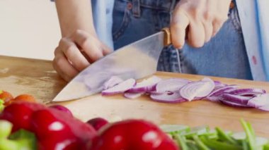 Mutfakta kırmızı soğan doğrayan, mutfakta sağlıklı salata hazırlayan kadın elleri.