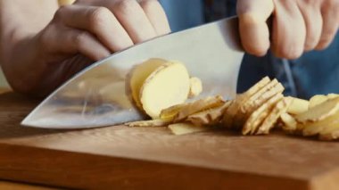 Doğal makrobiyotik. Evde çay içmek için taze zencefil dilimleyen kadın elleri. Kapatın.