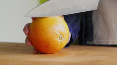 Kırmızı Sicilya portakalını dilimleyen kadına yakın çekim