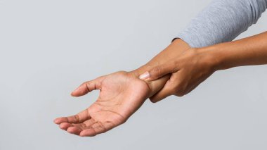 Close up of black woman holding her wrist, having pain from using computer. Office syndrome, joint pain by occupational disease.