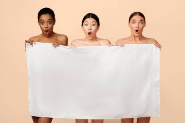 Beyaz Stüdyo Arkaplanındaki Kameraya Bakan Üç Şok Olan Manken Kız Banyo Havlusu Poz Veriyor. Vücut Bakımı ve Güzellik.