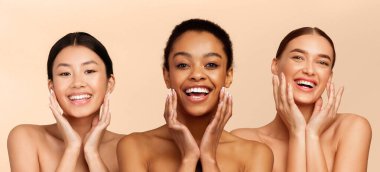 Yüz derisi. Üç farklı güzel kız birbirine dokunuyor, mükemmel cilt, kameraya gülümsüyor, Beyaz Stüdyo 'nun arka planında duruyor. Panorama