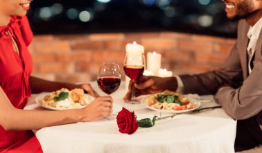 Tanımlanamayan siyah eşler romantik bir randevu geçiriyorlar şarap içip lüks bir restoranda yemek yiyorlar. Panorama, Kırpılmış, Seçici Odaklanma