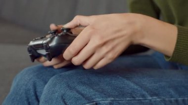 Modern hobi, evde joystick ile video oyunu oynayan duygusal genç kadının yakın çekimi, yavaş çekim.