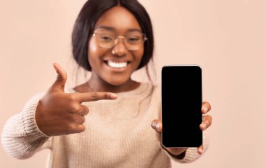 Pembe Stüdyo Arkaplanının Üzerinde Duran Boş Ekran 'a Telefon Gösteren Heyecanlı Siyah Kadın. Seçici Odaklanma, Model