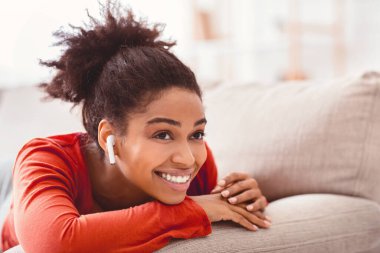 Hafta sonunun tadını çıkar. Kulaklıklı gülümseyen Afrikalı Amerikalı kız evde müzik dinliyor. Seçici Odaklanma