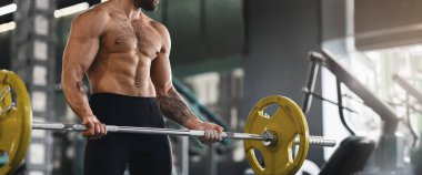 Güç kaldırma. Spor salonunda ağır halteri kaldıran kaslı adam, fotokopi alanı olan panorama.