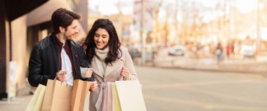 Alışveriş meraklıları alışveriş poşetlerine bakıyor, butiklerden alışveriş yaptıktan sonra eğleniyorlar, yer kopyalıyorlar.