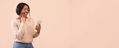 Heyecanlı Afro-Amerikan Kız Akıllı Telefonun Çene Tutma Parmağını Pembe Stüdyo Arkaplanının Üzerinde Tutuyor. Boş Boşluk