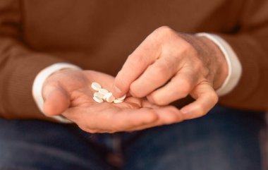 - Tıbbi tedavi. İhtiyarların Elleri Bir avuç dolusu reçeteli ilaç hapından bir hap alıyor. Seçici Odaklanma, Kırpılmış