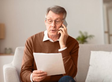 Üst düzey girişimci telefonda konuşuyor. İş arkadaşlarıyla evdeki koltukta oturarak çalışma belgesini tartışıyor. Seçici Odaklanma